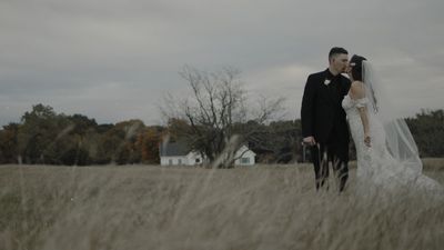 Bride and groom kiss in a tall grass field, autumn light