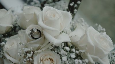 Engagement ring resting on a white rose bouquet