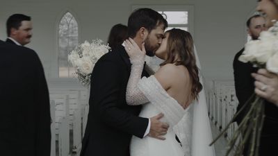 First kiss at the altar of an elegant white chapel