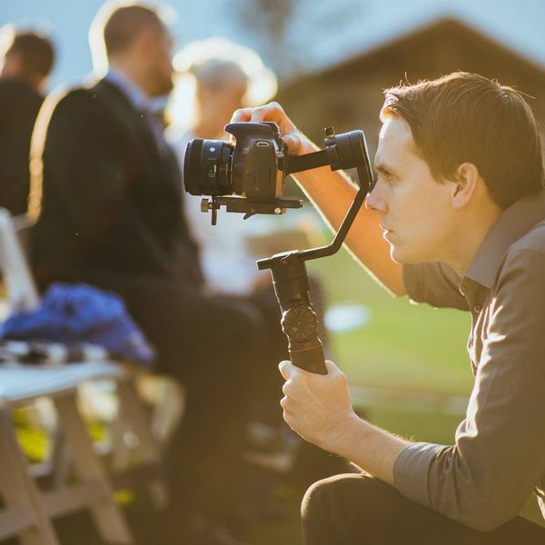 Wesley Blalock filming an outdoor wedding ceremony with gimbal at golden hour